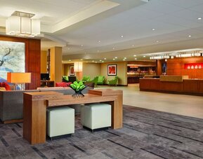 Spacious reception and lobby area featuring contemporary seating, colourful furnishings, artwork, and a front desk at Hyatt Place San Jose Downtown.