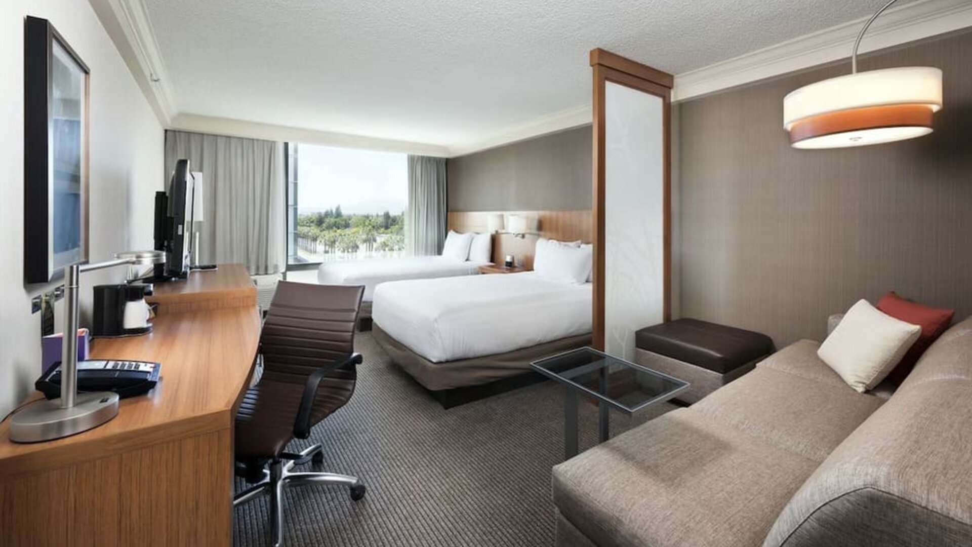 Accessible guest bathroom featuring a roll-in shower, grab bars, fold-down shower seat, and pedestal sink at Hyatt Place San Jose Downtown.  