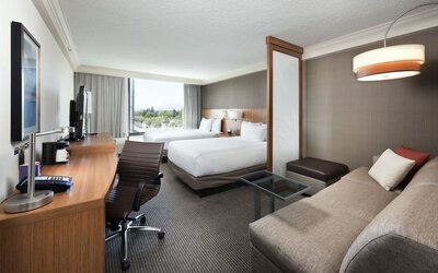 Accessible guest bathroom featuring a roll-in shower, grab bars, fold-down shower seat, and pedestal sink at Hyatt Place San Jose Downtown.  