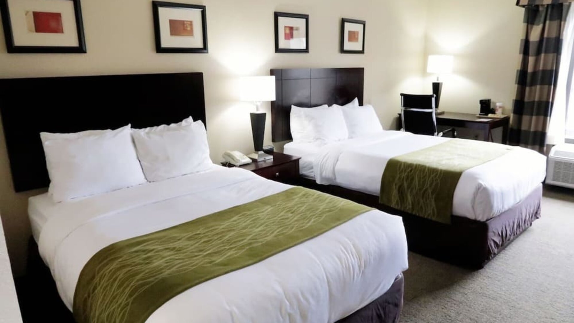 Guest room featuring two beds, bedside lighting, a work desk, chair, and large window at Comfort Inn Southwest At Westpark.
