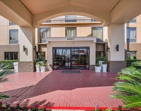 Covered front entrance featuring landscaped surroundings and glass entry doors at Comfort Inn Southwest At Westpark.