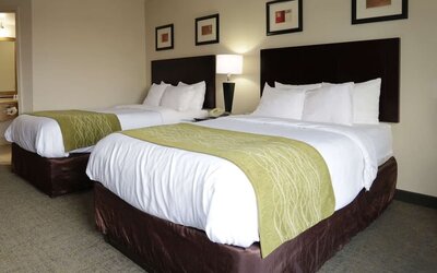 Spacious guest room featuring a king bed, sofa seating area, coffee table, workspace, and large window at Comfort Inn Southwest At Westpark.