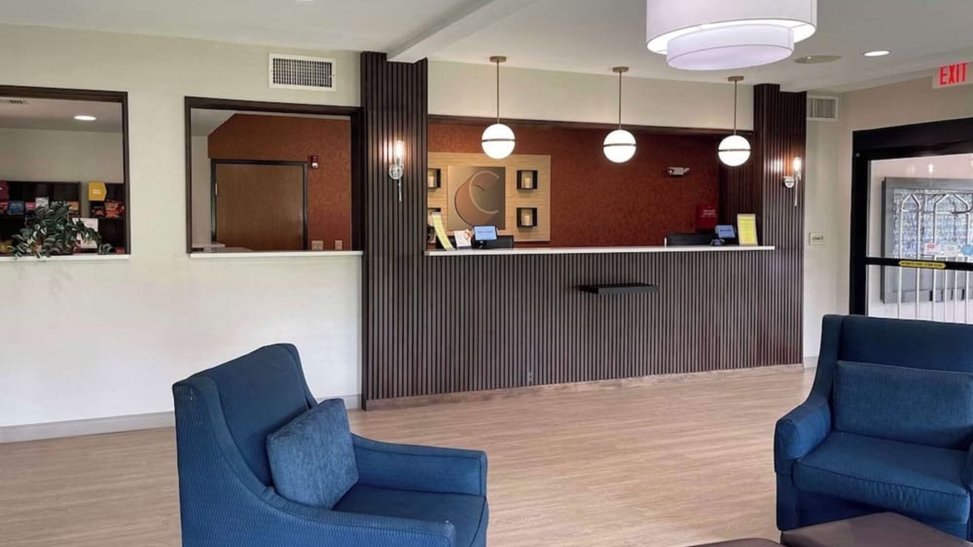 Reception area with front desk, pendant lighting, lounge chairs, and modern décor at Comfort Suites San Antonio SeaWorld - Lackland AFB.
