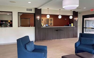Reception area with front desk, pendant lighting, lounge chairs, and modern décor at Comfort Suites San Antonio SeaWorld - Lackland AFB.