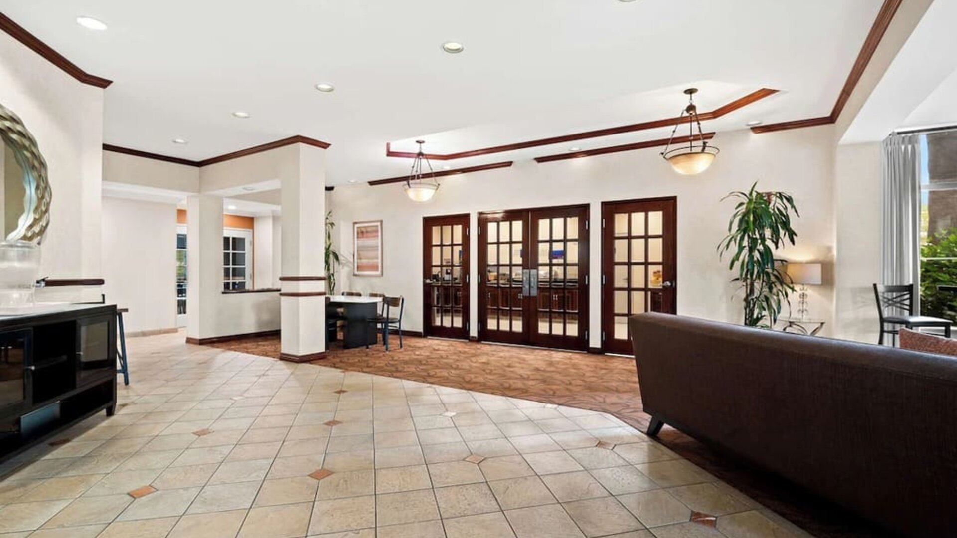 Spacious hotel lobby with tiled floors, seating areas, and French doors at Best Western Ontario Mills Mall.