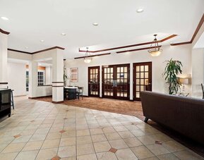 Spacious hotel lobby with tiled floors, seating areas, and French doors at Best Western Ontario Mills Mall.