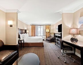Spacious king guest room with sofa, work desk, television, and seating area at Best Western Ontario Mills Mall.
