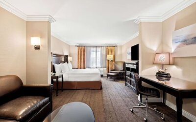 Spacious king guest room with sofa, work desk, television, and seating area at Best Western Ontario Mills Mall.