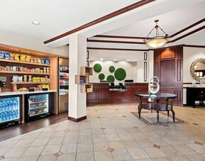 Reception area with front desk, marketplace stocked with snacks and drinks, and tiled flooring at Best Western Ontario Mills Mall.