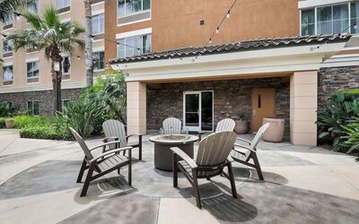Outdoor terrace with chairs arranged around a fire pit at Best Western Ontario Mills Mall.