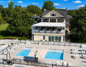 Outdoor pool area featuring multiple swimming pools, sun loungers, terrace seating, and the main resort building at SKYLARANNA Resort & Spa.