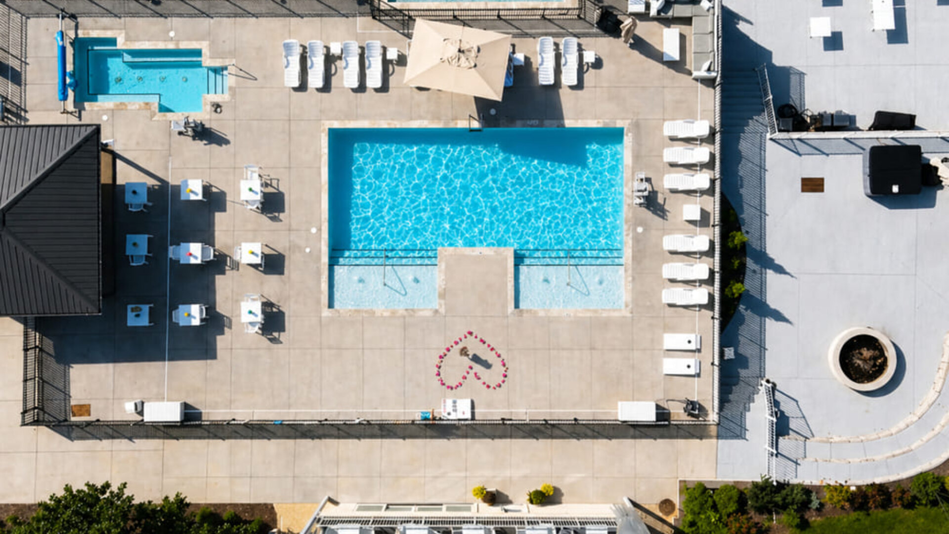 Aerial view of the outdoor pool complex featuring multiple pools, sun loungers, and surrounding deck area at SKYLARANNA Resort & Spa.