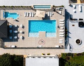 Aerial view of the outdoor pool complex featuring multiple pools, sun loungers, and surrounding deck area at SKYLARANNA Resort & Spa.
