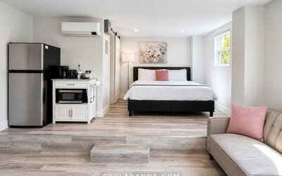 Spacious guest accommodation featuring a bed, sofa, refrigerator, kitchenette, and bright contemporary furnishings at SKYLARANNA Resort & Spa.