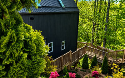 Landscaped resort grounds featuring lush greenery, flowering plants, wooden walkways, and surrounding trees at SKYLARANNA Resort & Spa.