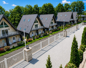 Exterior view featuring chalet-style guest buildings, landscaped grounds, and a paved walkway at SKYLARANNA Resort & Spa.