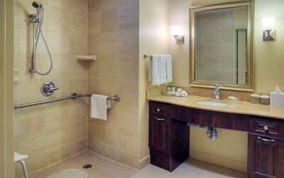 Guest bathroom with shower and toiletries at Homewood Suites By Hilton Burlington.