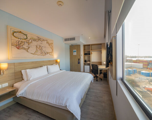 Spacious king guest room featuring abundant natural light, a dedicated workspace, and large windows overlooking the port at Holiday Inn Express Cartagena Manga.