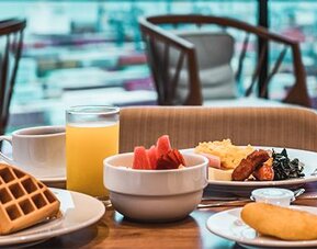 Breakfast spread featuring waffles, fresh fruit, pastries, juice, and hot breakfast selections at Holiday Inn Express Cartagena Manga.