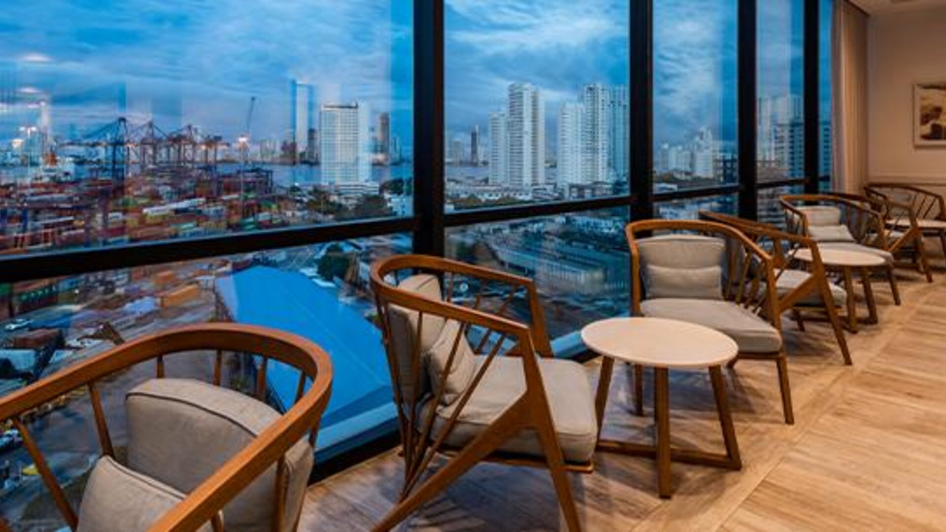 Comfortable lounge seating beside floor-to-ceiling windows overlooking the city and port at Holiday Inn Express Cartagena Manga.