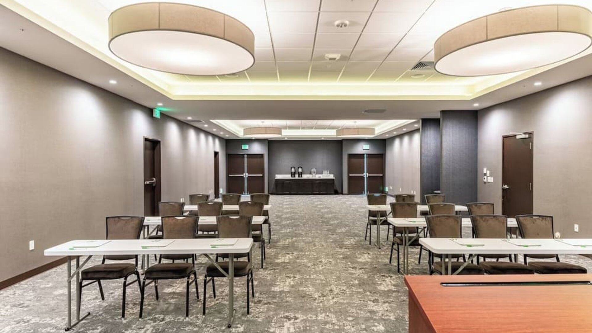 Spacious meeting facility featuring classroom-style tables and chairs, presentation space, and modern lighting at Holiday Inn & Suites Silicon Valley - Milpitas.