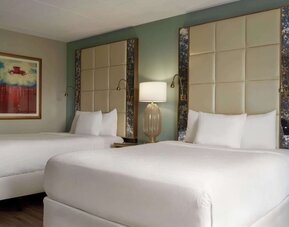 Comfortable guest room featuring two beds, contemporary headboards, bedside lighting, and modern décor at Wyndham Garden Pittsburgh Airport.