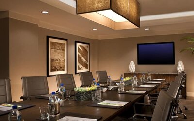 Professional meeting room with glasses of water and writing pads with pictures on the wall. 
