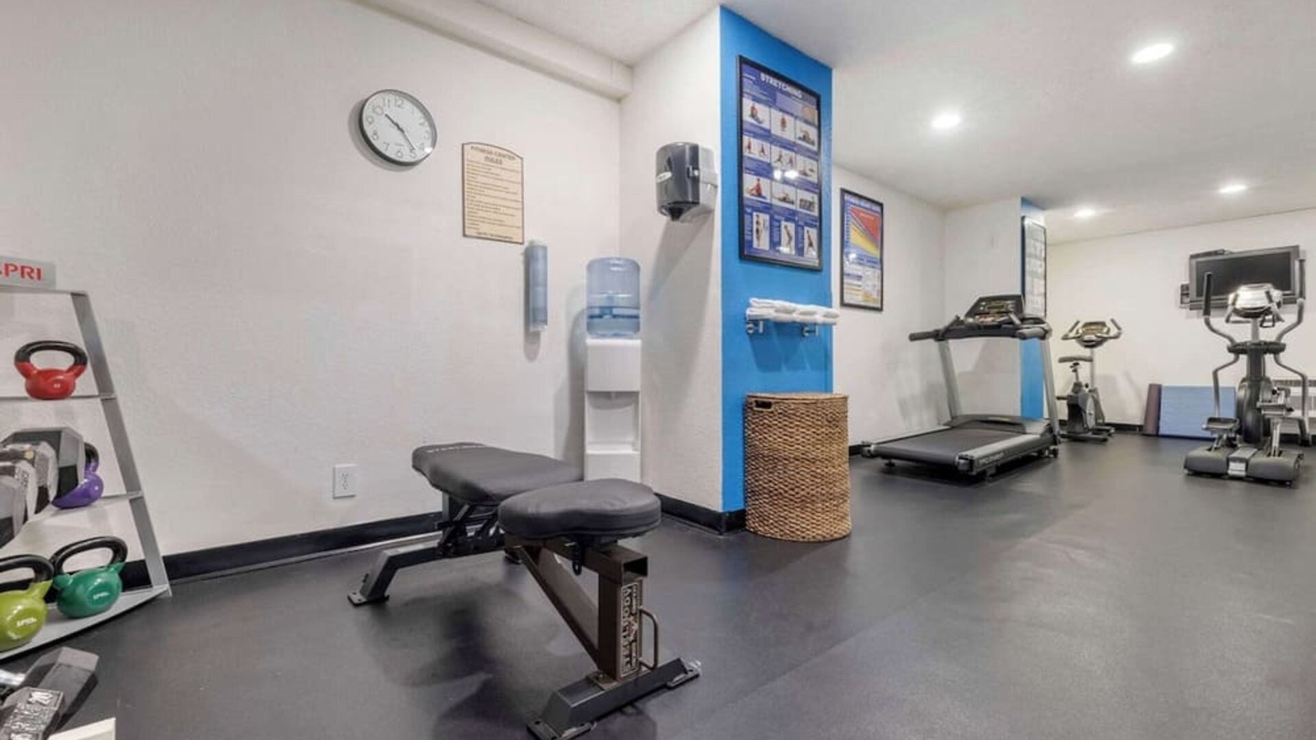Fitness centre featuring a treadmill, exercise bike, elliptical machine, weight bench, and kettlebells. Best Western McCarran Inn.