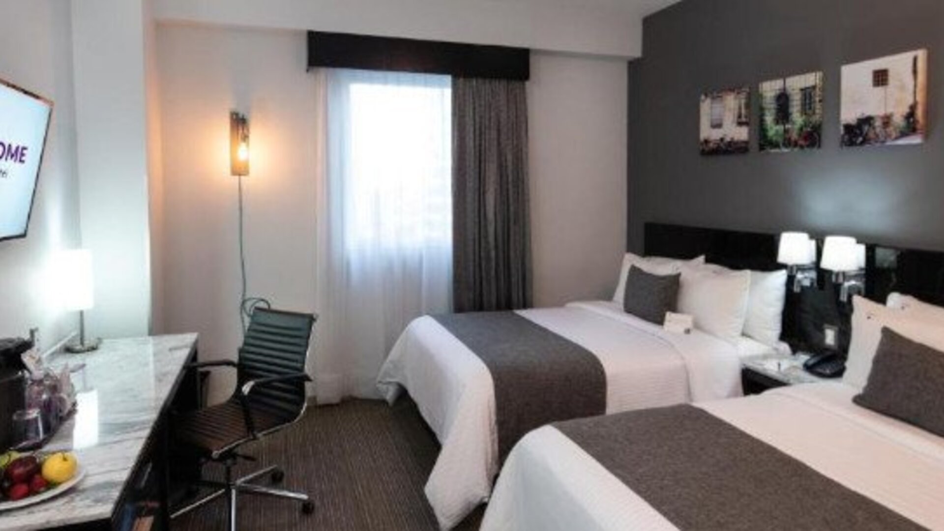 Guest room featuring two beds, a work desk, flat-screen TV and contemporary décor. LaiLa Hotel CDMX.