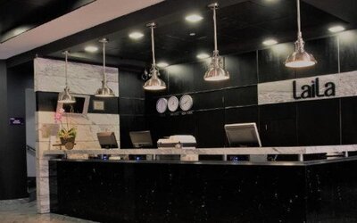 Modern reception desk featuring black and marble finishes with pendant lighting. LaiLa Hotel CDMX.