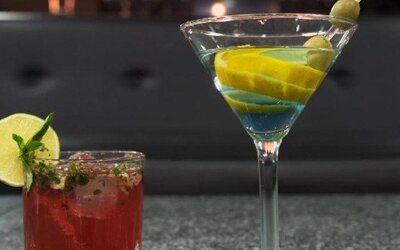 Two colourful cocktails served at the hotel bar, including a martini garnished with olives and citrus. LaiLa Hotel CDMX.