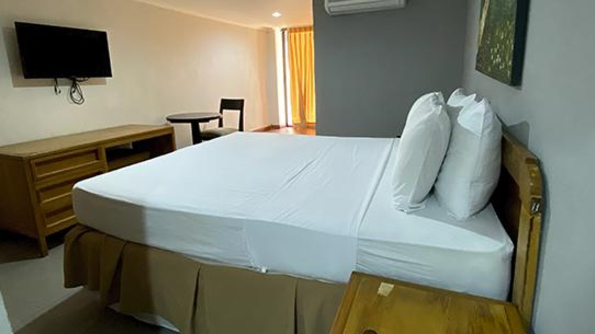 Guest room with double bed, television, desk and air conditioning at Hotel Puerta de Oro.