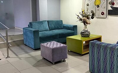 Modern hotel lobby with teal sofa, patterned seating, coffee table and artwork at Hotel Puerta de Oro.