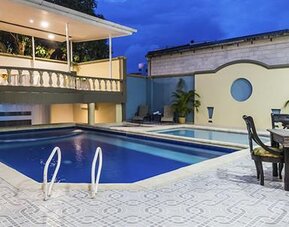 Outdoor swimming pool with patio dining area and covered terrace at Hotel Puerta de Oro.