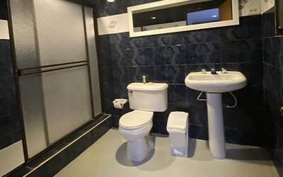 Accessible hotel bathroom with bathtub, shower seat, grab bars and toiletries at Hotel Puerta de Oro.