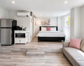 Spacious guest accommodation featuring a bed, sofa, dining area, refrigerator, kitchenette, and contemporary furnishings at SKYLARANNA Resort & Spa.