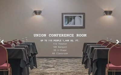 Conference room set up for meetings and events with banquet tables and red chairs at EnVision Hotel St. Paul South.