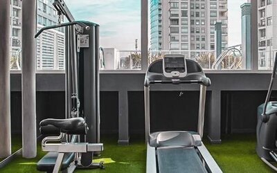 Fitness center with cardio and strength equipment, artificial grass flooring, and city views at Dazzler by Wyndham Polo.