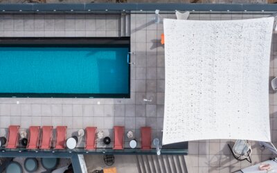 Aerial view of the rooftop pool, surrounding lounge chairs, canopy, and terrace seating at Hotel ibis Styles Barcelona City Bogatell.