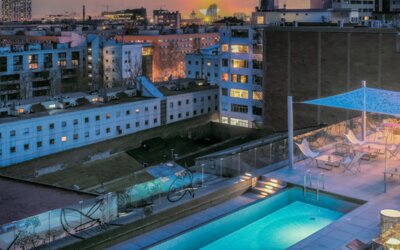 Rooftop pool with lounge chairs, glass railings, canopy, and surrounding city buildings at Hotel ibis Styles Barcelona City Bogatell.