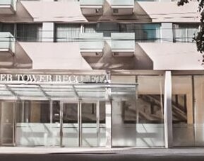 Hotel entrance with glass doors, covered canopy, balconies, and signage above the entrance at Dazzler by Wyndham Buenos Aires Recoleta.