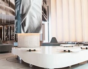 Modern hotel lobby with sculptural white seating, large digital artwork, and floor-to-ceiling windows at Dazzler by Wyndham Buenos Aires Recoleta.