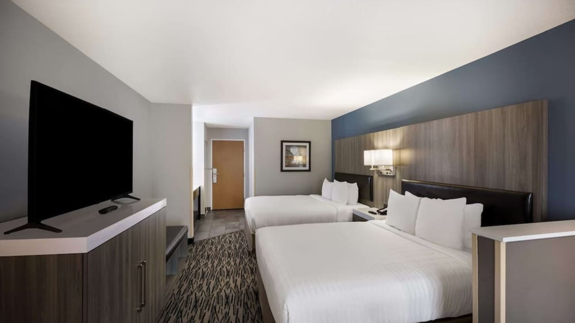Guest room with two beds, a television, dresser, desk, and seating area at Best Western Plus Mountain View Auburn Inn.
