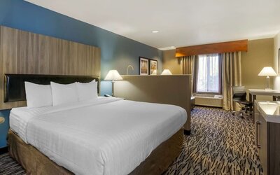 King guest room with large bed, bedside tables, desk, and window at Best Western Plus Mountain View Auburn Inn.