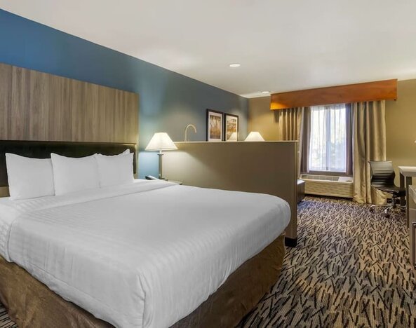 King guest room with large bed, bedside tables, desk, and window at Best Western Plus Mountain View Auburn Inn.