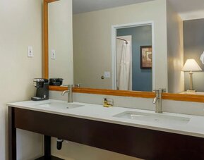 Double-sink vanity with a large mirror, coffee maker, and towels at Best Western Plus Mountain View Auburn Inn.
