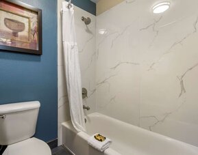 Bathroom with a bathtub, shower, toilet, and marble-look wall surround at Best Western Plus Mountain View Auburn Inn.