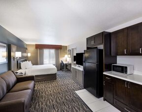 Spacious suite with a king bed, sofa, kitchenette, refrigerator, microwave, and desk at Best Western Plus Mountain View Auburn Inn.