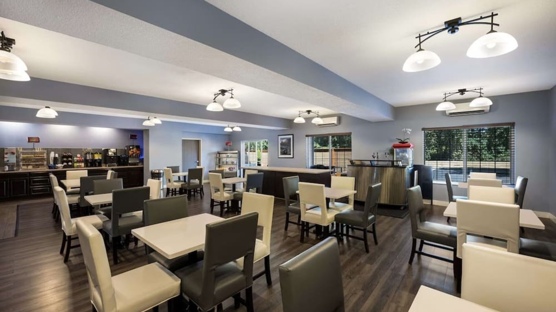 Breakfast area with tables, chairs, buffet, coffee station, and large windows at Best Western Plus Mountain View Auburn Inn.