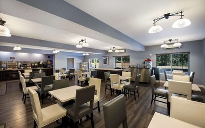 Breakfast area with tables, chairs, buffet, coffee station, and large windows at Best Western Plus Mountain View Auburn Inn.